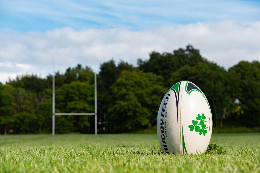 pexels-photo-16566965-16566965 Rugby ball on a grassy pitch in Galway, Ireland during summer.